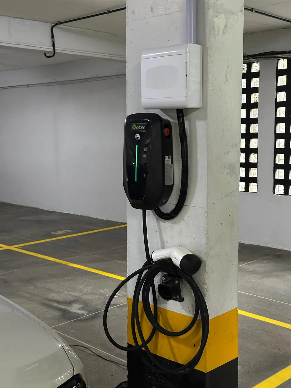 Carregador de parede com botão de emergência e caixa de proteção instalados em pilar de garagem de condomínio