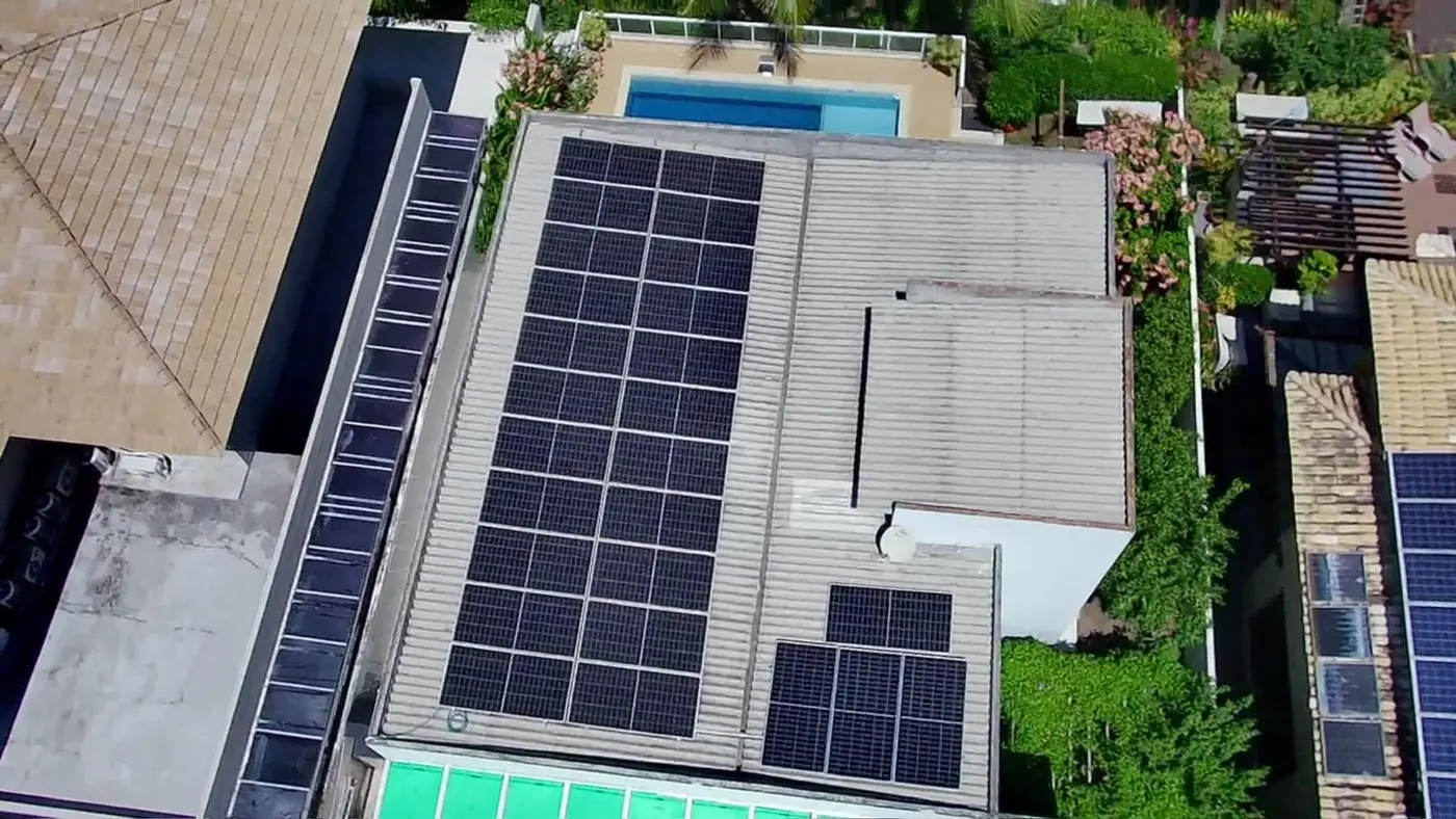 Residência com módulos fotovoltaicos na cobertura, vista aérea